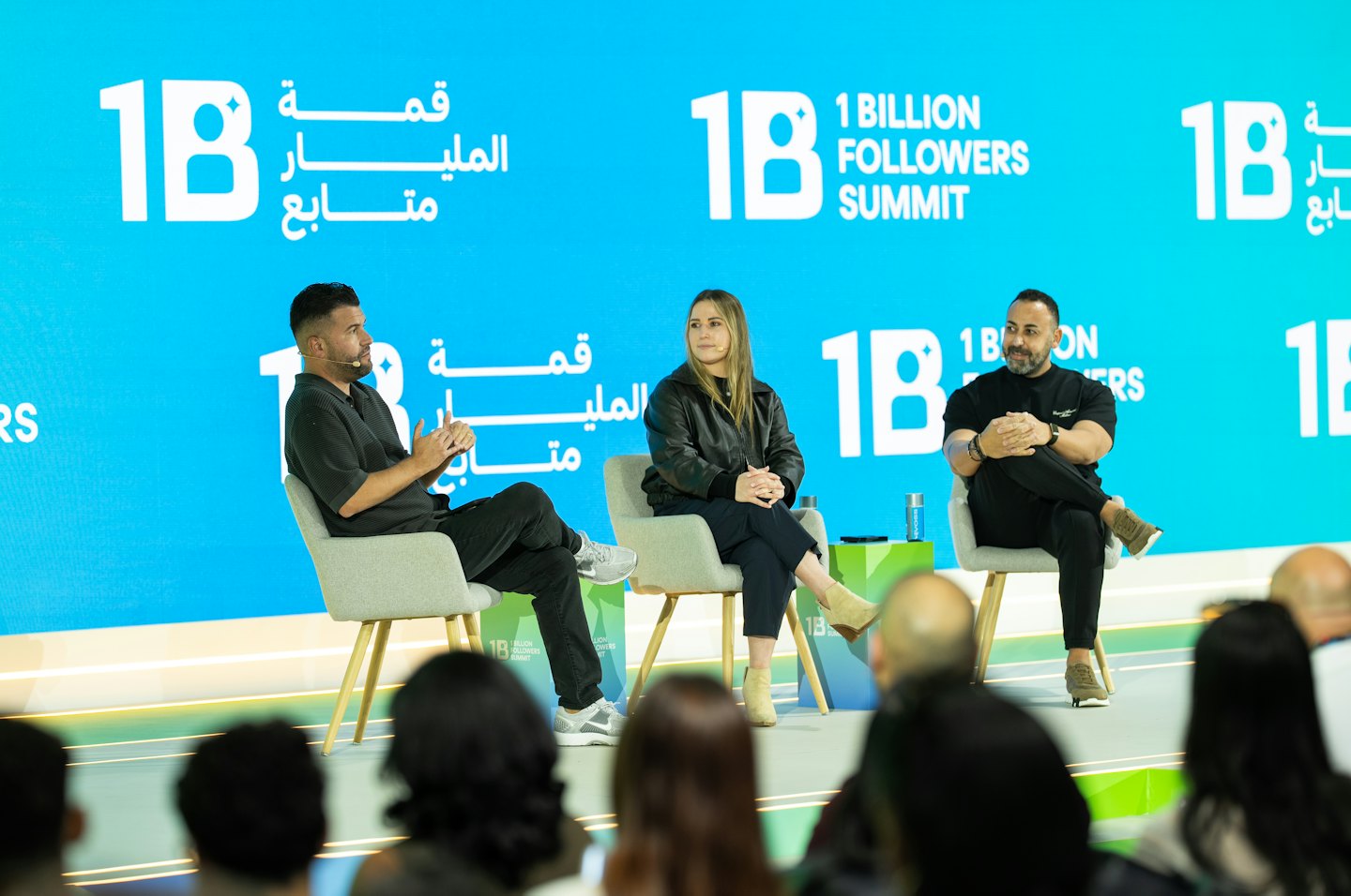 Panelists discuss topics on a stage at an indoor conference.